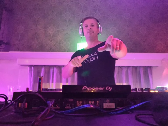 Sjon wijst naar het publiek vanuit de booth