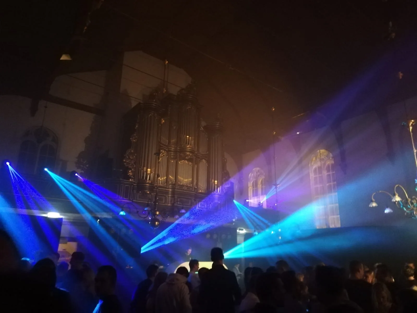 Blauwe lichtbundels boven het publiek in de kerk